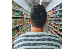 Image Man standing in front of shelves in store.